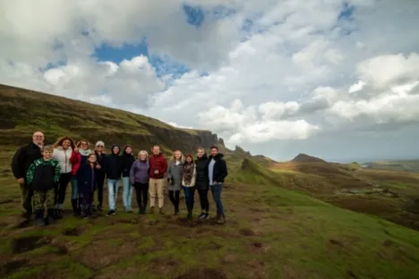 a group of people standing on a grassy hill
