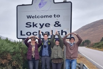 a group of people standing in front of a sign