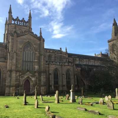 a large stone statue in front of a church