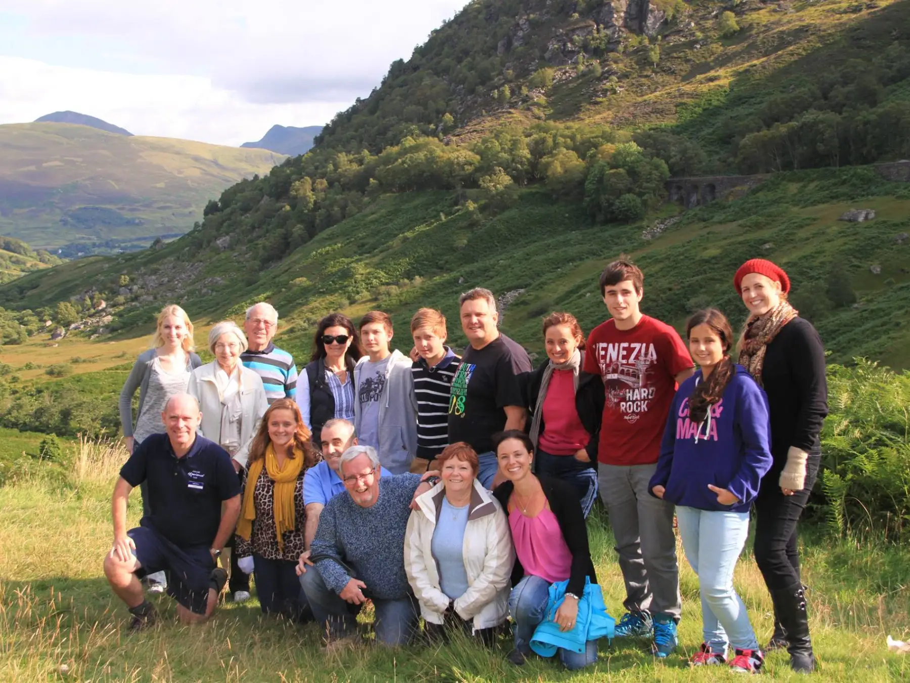 a group of people posing for a photo in front of a mountain