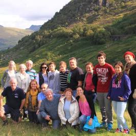 a group of people posing for a photo in front of a mountain