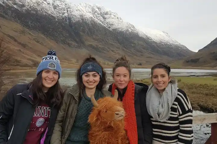a group of people posing in front of a mountain