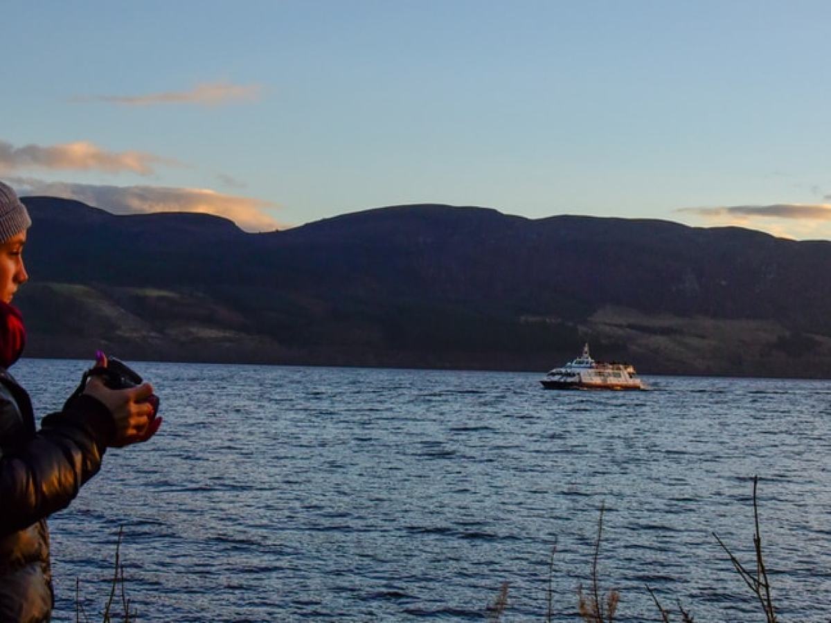 a man standing next to a body of water