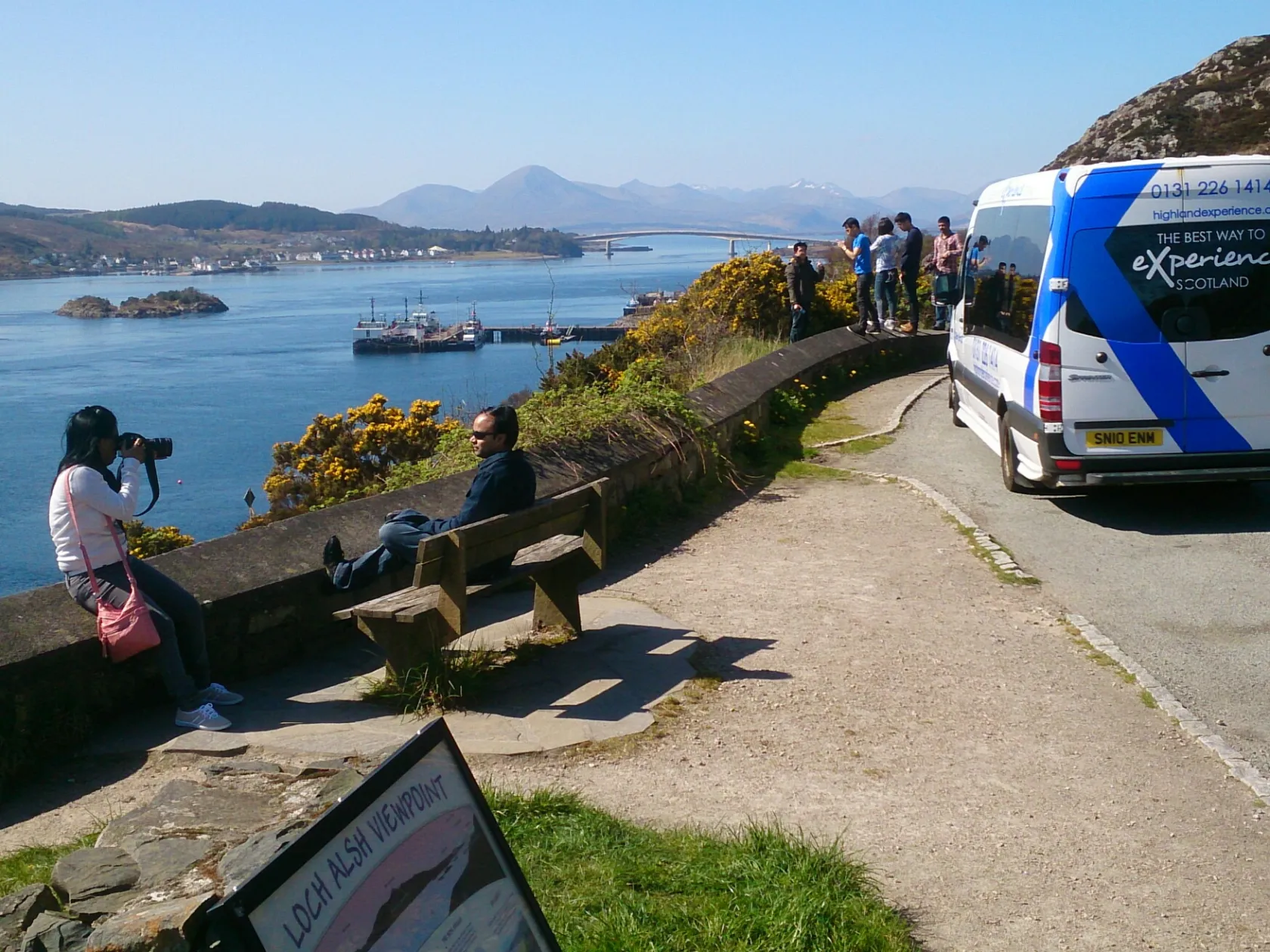 a group of people sitting on a bench next to a body of water
