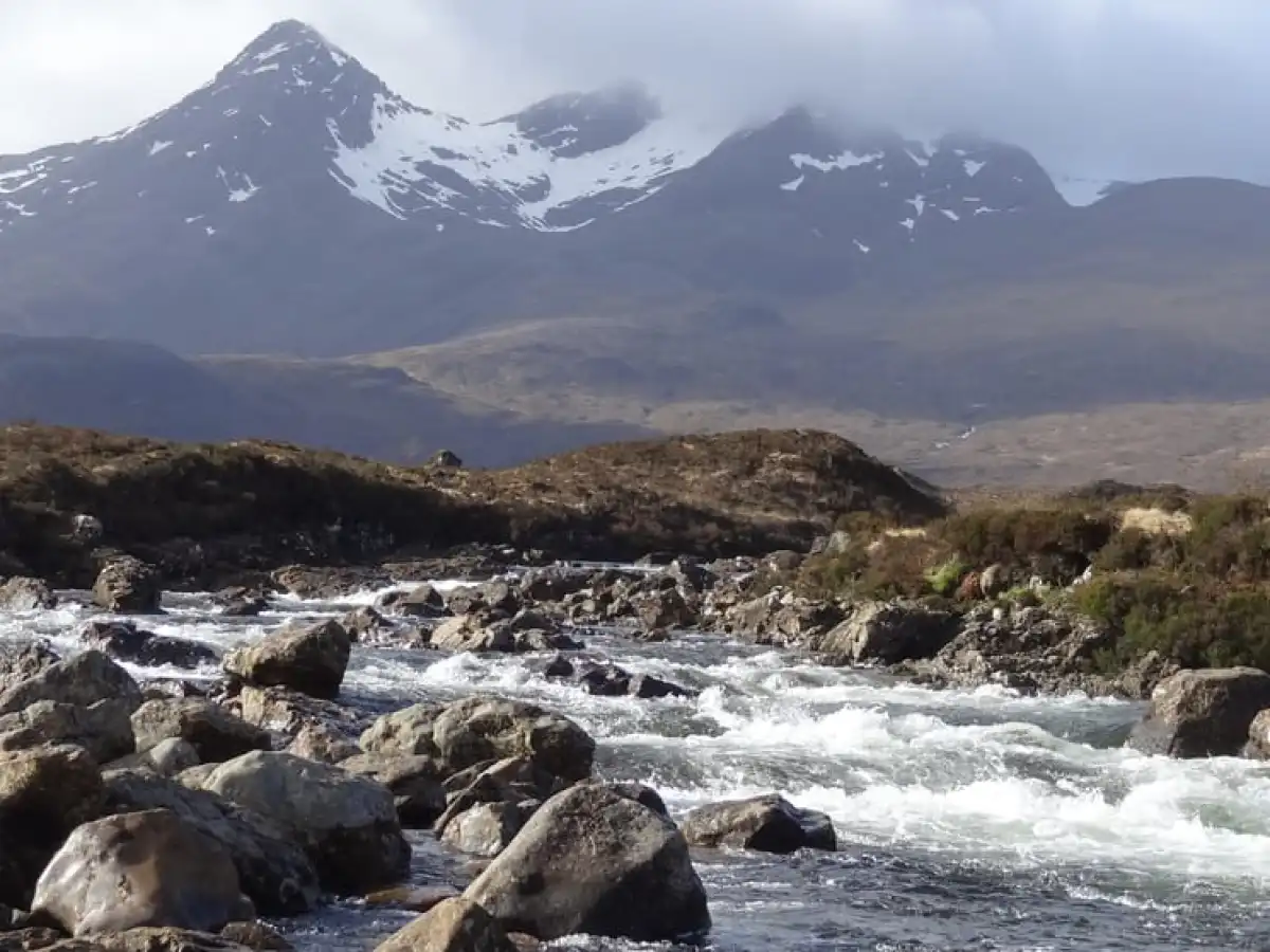 a rocky island in the middle of a snow covered mountain