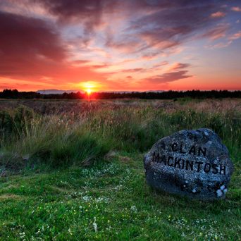 a sunset over a grass field