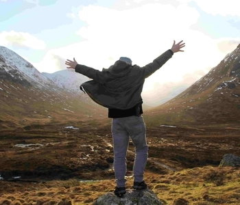experience-glencoe a man standing on top of a mountain