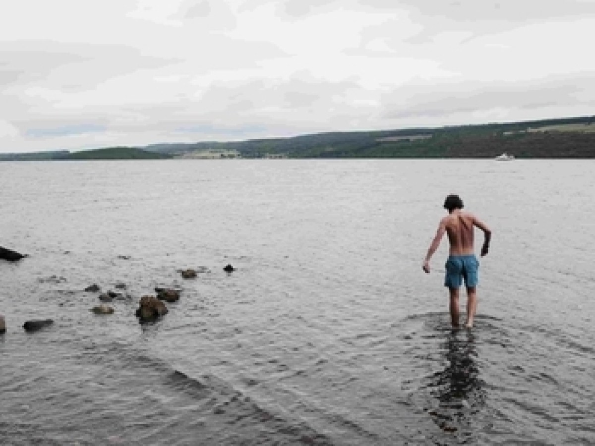 a person standing on a beach near a body of water