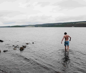 loch-ness-dip a person standing on a beach near a body of water