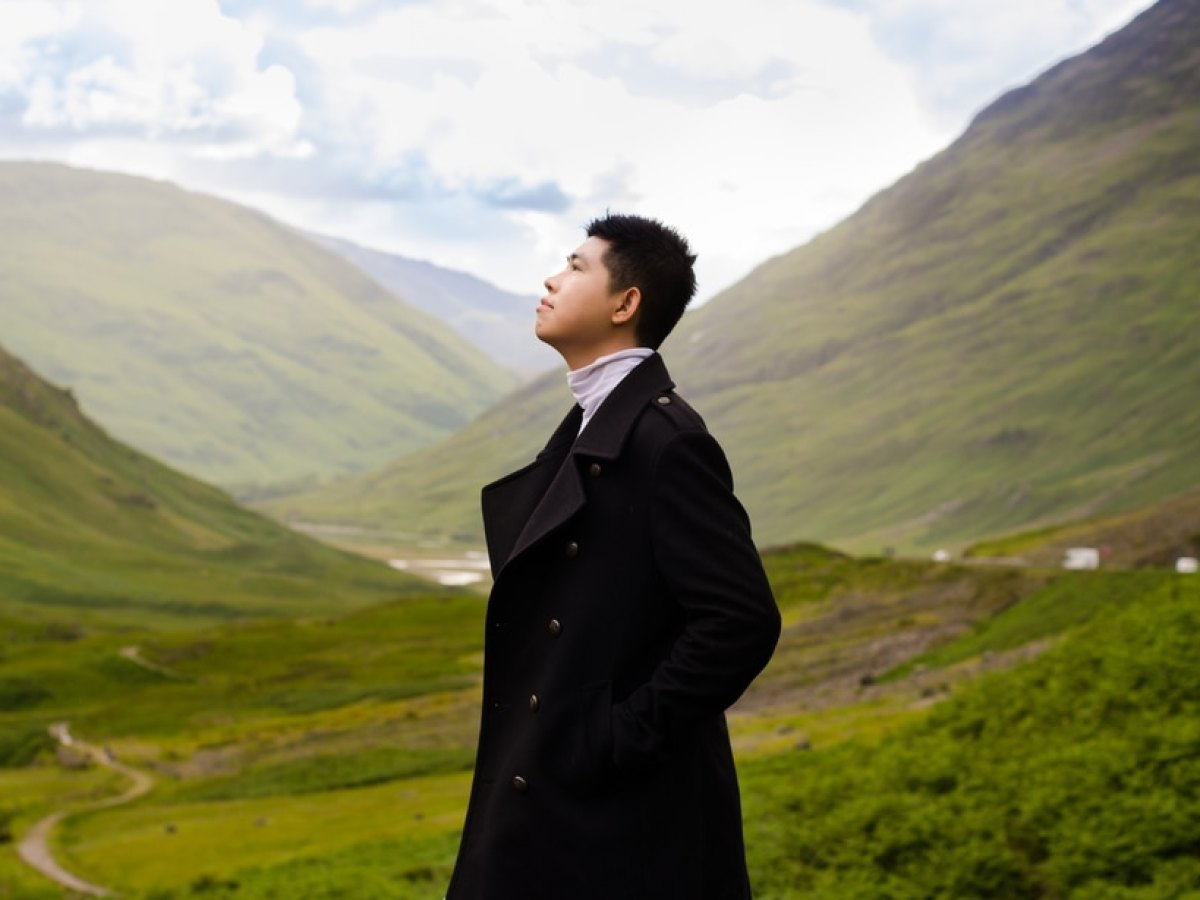 a man standing on a grassy hill