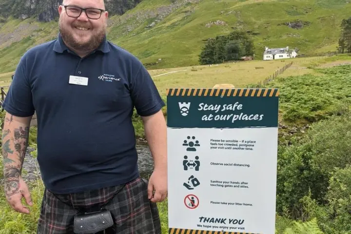 a man holding a sign posing for the camera