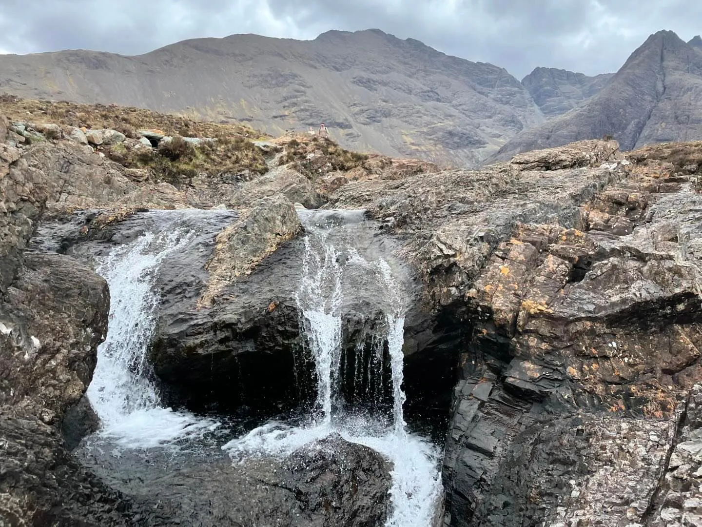 a waterfall with a mountain in the background