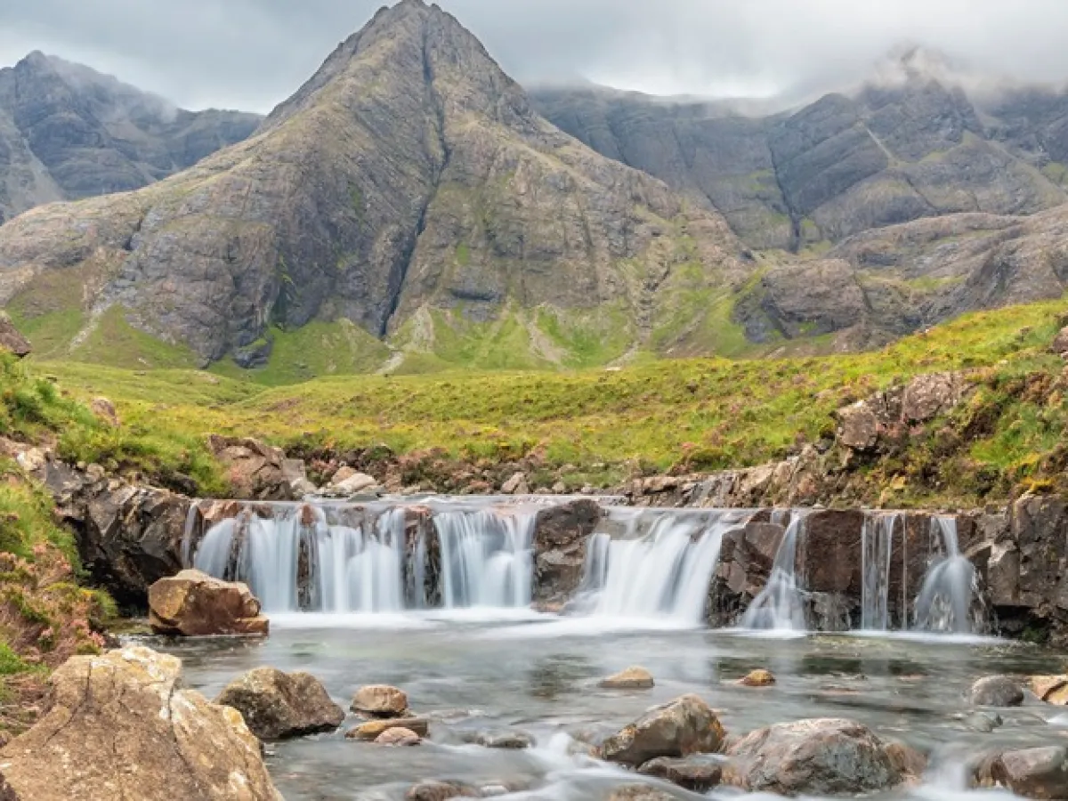 a waterfall with a mountain in the background