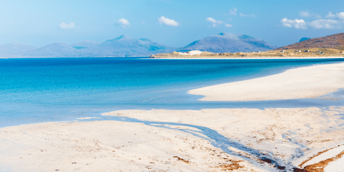 a sandy beach next to a body of water