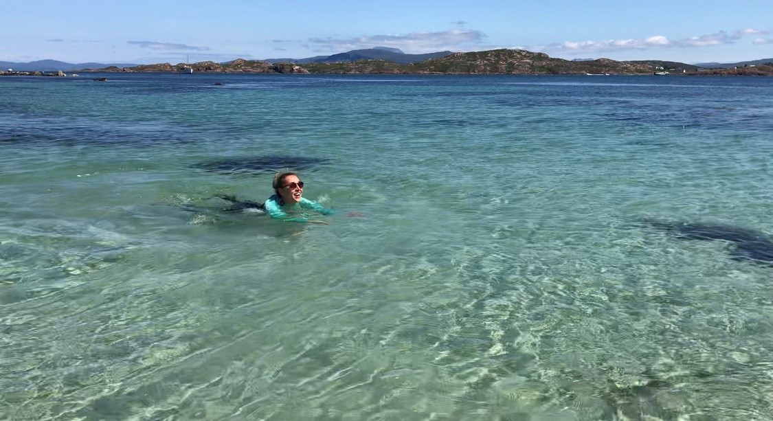swim a man riding a wave on a surf board on a body of water