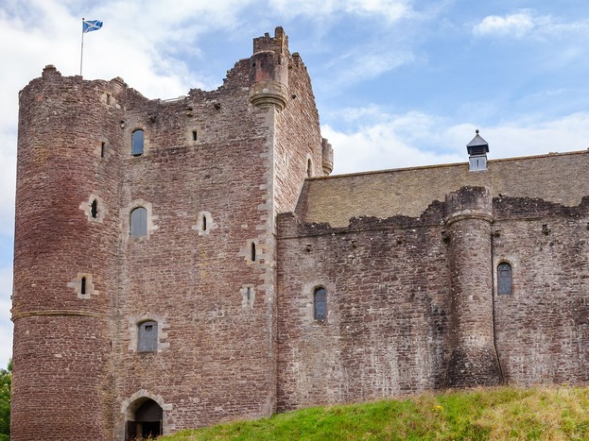 a stone castle next to a brick building