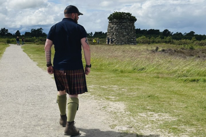 a man standing on top of a grass covered field