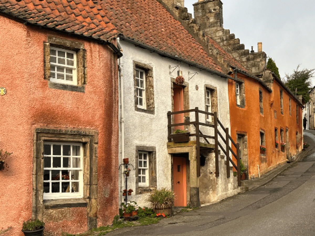 Colorful historic cottages on a sloped street with vibrant facades and charming windows.