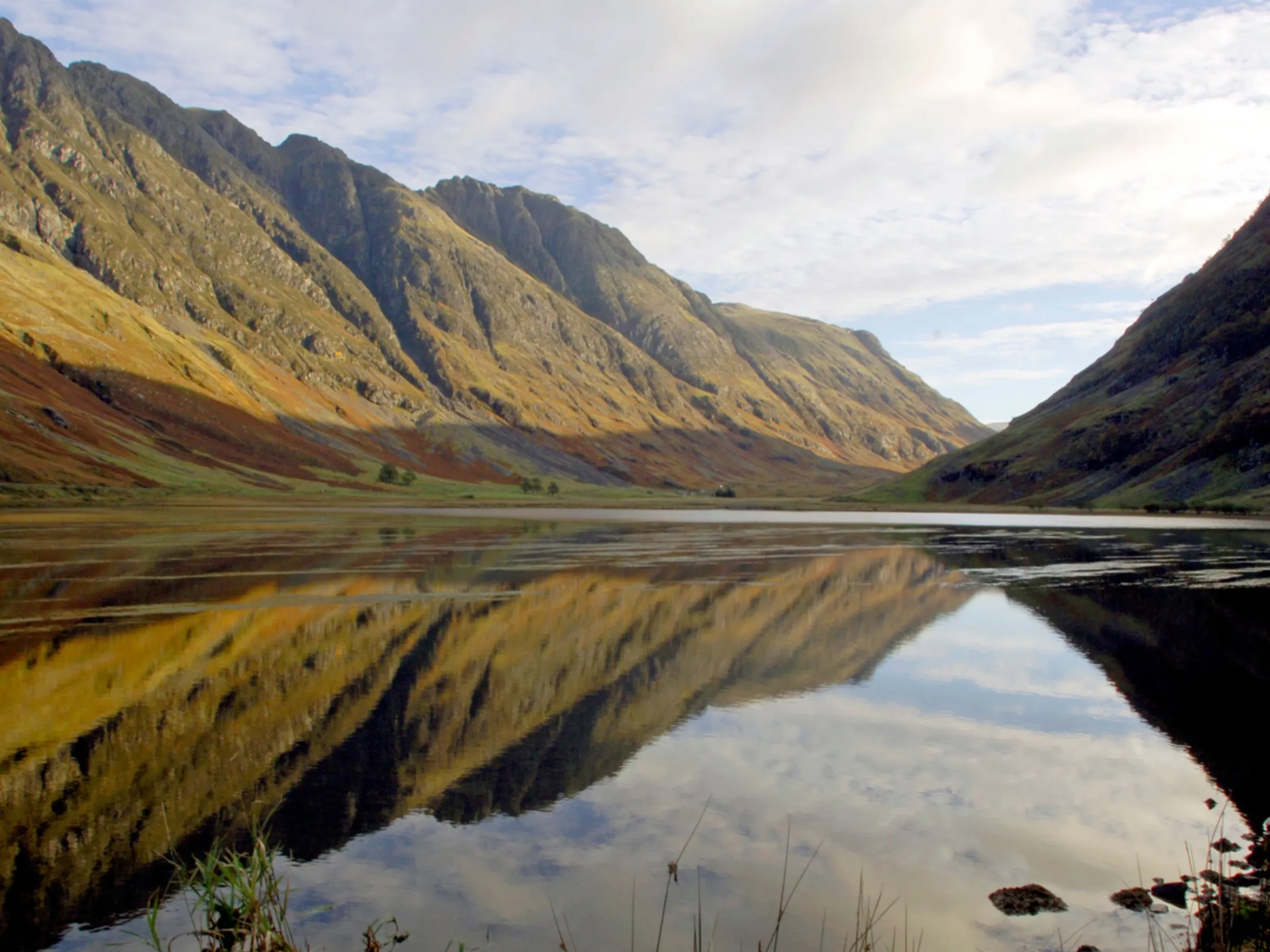 Mountain landscape with a clear lake reflecting the sky and peaks.