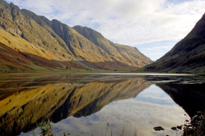 Mountain landscape with a clear lake reflecting the sky and peaks.