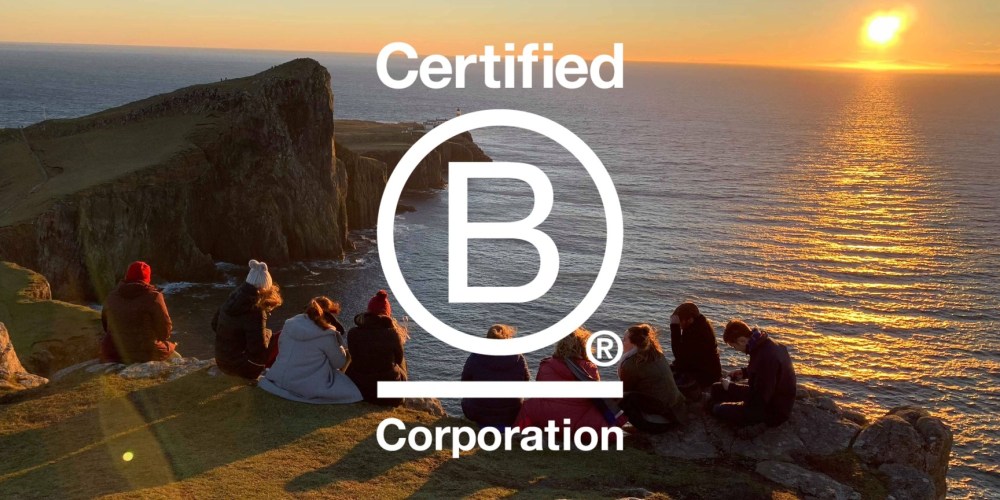 Group sitting on cliff at sunset with 'Certified B Corporation' logo overlaid.