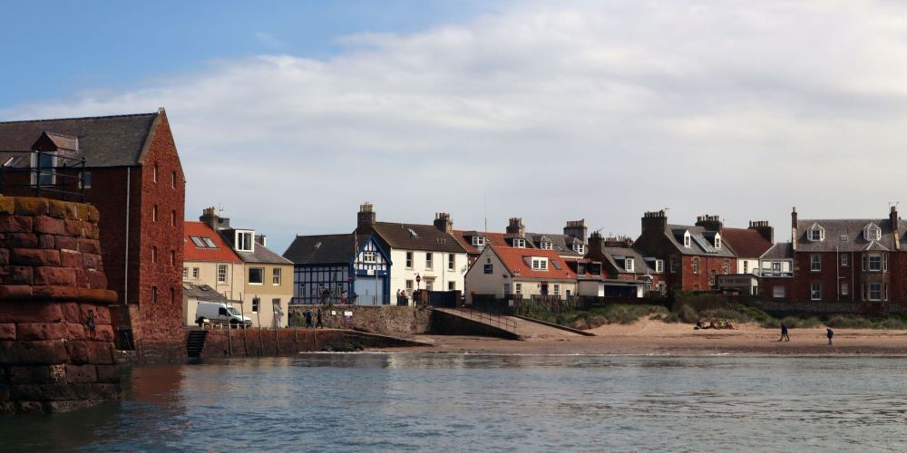 Coastal village houses by the water with blue sky.