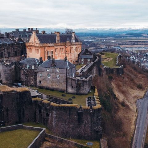 Aerial view of a castle on a hill with surrounding landscape.